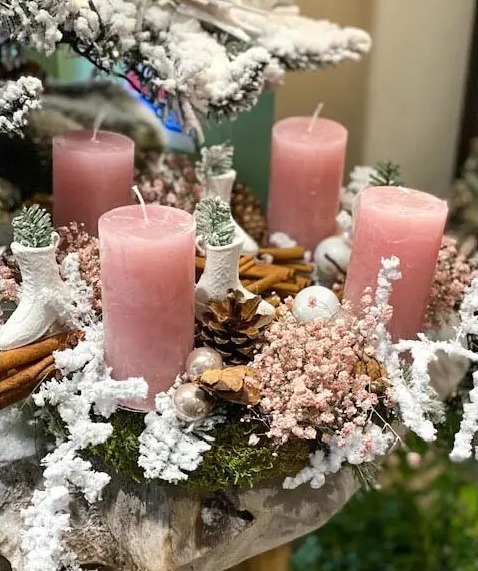 A Christmas wreath with four pink candles