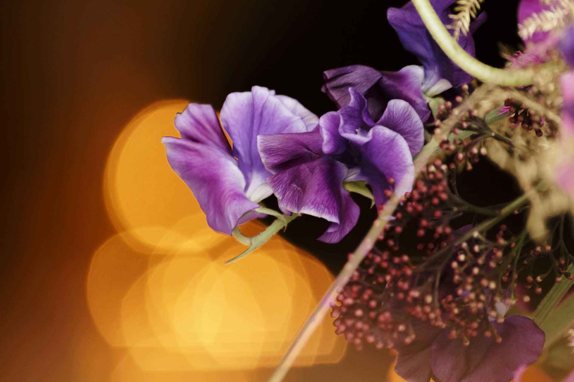 Un centre de table fleuri, haut et moderne, pour décorer les tables d'un restaurant à Monaco à l'occasion d'un événement fleur par le fleuriste Narmino